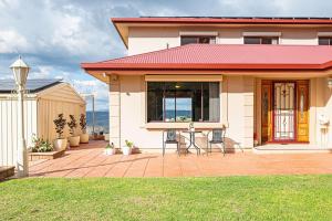 una casa con due sedie su un patio in mattoni di Goldfields View a One Tree Hill