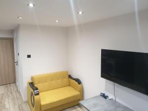 un soggiorno con sedia gialla e TV a schermo piatto di Sikalafo1 a Płock