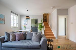 a living room with a blue couch and a staircase at L'Attico del Corso in Trieste