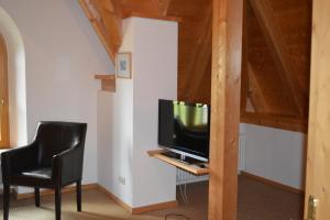 a living room with a television and two chairs at Ferienwohnungen am Bullachberg in Schwangau