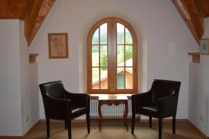 a room with two chairs and a table and a window at Ferienwohnungen am Bullachberg in Schwangau