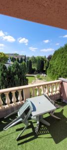a bench on a balcony with a view of a park at Côté Jardin in Commercy