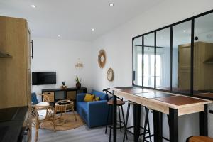 a living room with a blue couch and a table at Cosy Gare in Caen
