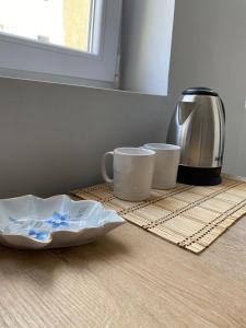 Un mostrador con dos tazas de café y una cafetera. en AVENUE Apartment 01 Tirana, en Tirana