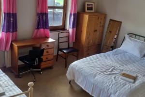 a bedroom with a bed and a desk and a chair at ocean fields view in Ahnagh Cross
