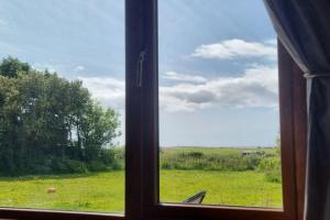 a window with a view of a field of grass at ocean fields view in Ahnagh Cross