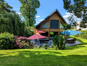 a house with two umbrellas in the yard at Les Chambres D'oriane in Chessy