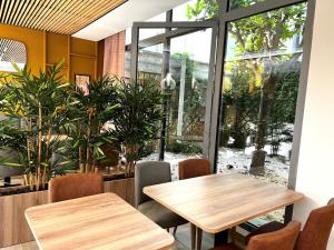 two tables and chairs in a restaurant with a large window at Hôtellerie L'Enclos Rey in Paris