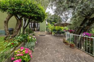 un jardin avec une table, des fleurs et une clôture dans l'établissement Villa Verde, à Torri del Benaco