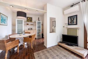 un salon avec une table et une télévision dans l'établissement Villa Verde, à Torri del Benaco