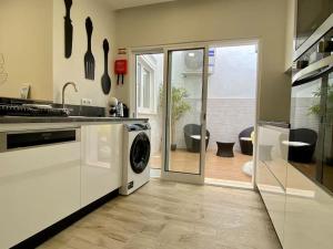 eine Küche mit Waschmaschine und Trockner in der Unterkunft Casa Amarela by CORAL in Portimão