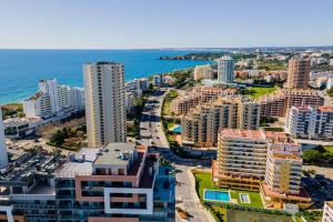 eine Luftaufnahme einer Stadt mit Gebäuden und dem Meer in der Unterkunft Casa Amarela by CORAL in Portimão