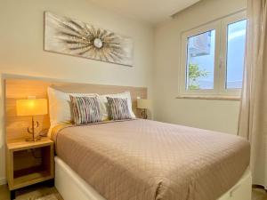 ein Schlafzimmer mit einem Bett und einem Fenster in der Unterkunft Casa Amarela by CORAL in Portimão