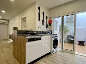 eine Küche mit Spüle und Waschmaschine in der Unterkunft Casa Amarela by CORAL in Portimão