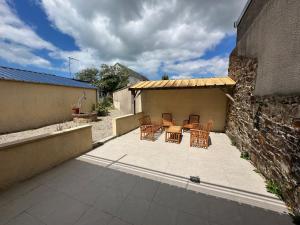 a patio with a table and chairs and a building at Barneville Plage in Barneville-Carteret