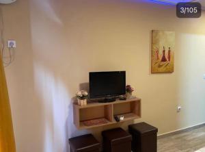 a flat screen tv sitting on a shelf in a room at Dreams Rooms in Dušanovac (historical)