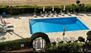 a swimming pool with lounge chairs and a bunch at Two bedroom apartment with pool in Paphos