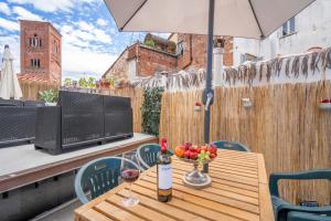 een tafel met een fles wijn en een schaal fruit bij Lucca Old Town Apartment in Lucca