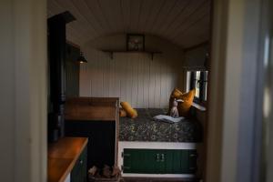 a small room with a bed with a doll on it at Four Acres Farm in Donaghadee