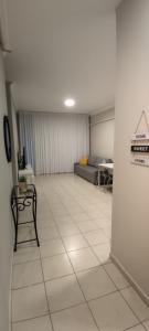 a living room with a couch and a tiled floor at Mediterranean Sea View in Ashqelon
