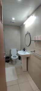 a bathroom with a toilet and a sink and a mirror at Mediterranean Sea View in Ashqelon