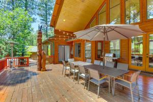 a patio with a table and chairs and an umbrella at Hot Tub and Game Room All-Season Pinetop Cabin in Pinetop-Lakeside