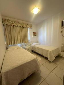 a hotel room with two beds and a window at Caldas Novas - Prive das Thermas II - Apto 3 quartos - Parque Aquático in Caldas Novas +49 photos