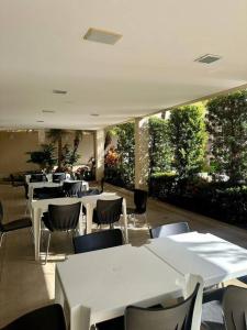 a dining room with white tables and chairs at Caldas Novas - Prive das Thermas II - Apto 3 quartos - Parque Aquático in Caldas Novas