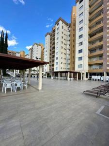 a large parking lot with white chairs and buildings at Caldas Novas - Prive das Thermas II - Apto 3 quartos - Parque Aquático in Caldas Novas