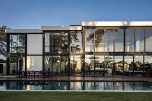 a large glass house with a pool in front of it at VILLA GIMA 1 - 5 bedroom UMALAS in Kerobokan