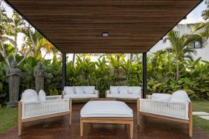 a gazebo with white couches and tables at VILLA GIMA 1 - 5 bedroom UMALAS in Kerobokan