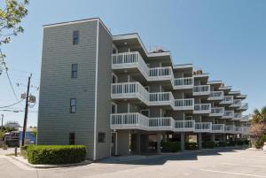 a tall building with white balconies on it at Shearin by Bryant Real Estate in Wrightsville Beach