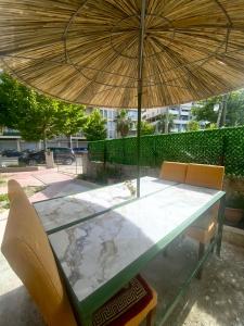 una mesa con una sombrilla y dos sillas debajo en At-Salaj3, en Vlorë
