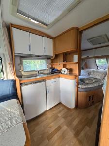 an rv kitchen with white cabinets and a sink at Camperowe Swawole - Bondi in Bielawa