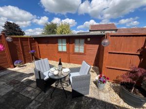 バースにあるCosy countryside stay near Bath with free parkingのパティオ(テーブル、椅子、フェンス付)