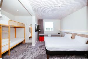 a bedroom with two beds and a bunk bed at Ibis Luxembourg Airport in Luxembourg +37 photos