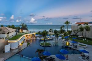an aerial view of a resort with a pool and the ocean at Marupiara Resort by Wish in Porto De Galinhas