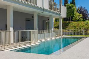 a swimming pool in front of a house with a balcony at Panoramic Apartment Rudi in Garda