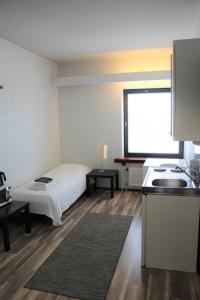 a room with a bed and a kitchen with a window at Forenom Apartments Rauhankatu 16 in Lahti