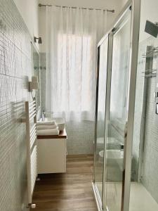 a bathroom with a glass shower and a sink at Airoldi Palace Apartment in Chioggia