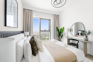 una camera da letto bianca con un letto grande e una scrivania di Silkhaus Elegant 1BDR in Downtown Views II a Dubai Altre 9 foto