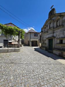 a cobblestone street in front of an old building at Casa da Capela in Entre Ambos os Rios