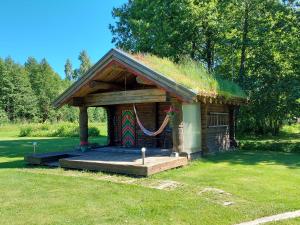 a small building with a grass roof with a porch at Mirteli Talu in Tahkuranna