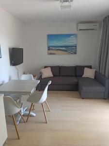 a living room with a couch and a table at Olive Tree Apartment Zečevo in Rogoznica +30 photos