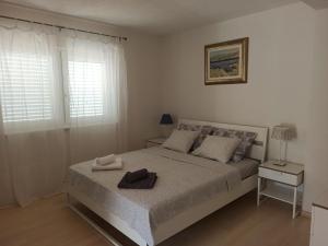 a bedroom with a bed with two towels on it at Olive Tree Apartment Zečevo in Rogoznica