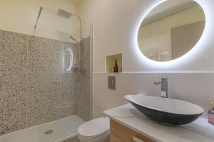 Un baño con lavabo, inodoro y espejo. en Selva, appartement cozy, Lyon 8ème, en Lyon 16 fotos más