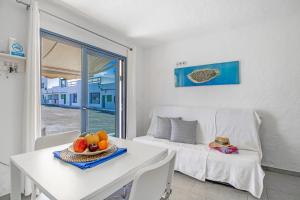 a living room with a white table and a white couch at La Casita Del Mar in Caleta de Caballo