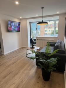 a living room with a black couch and a table at CentraLuxury in Piatra Neamţ