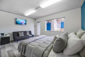 Un dormitorio con una cama, un sofá y un televisor. en The mariner Suites #22 - Beachfront Studio, en Hollywood