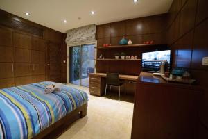 a bedroom with a bed and a desk and a television at La Villa Eilat in Eilat